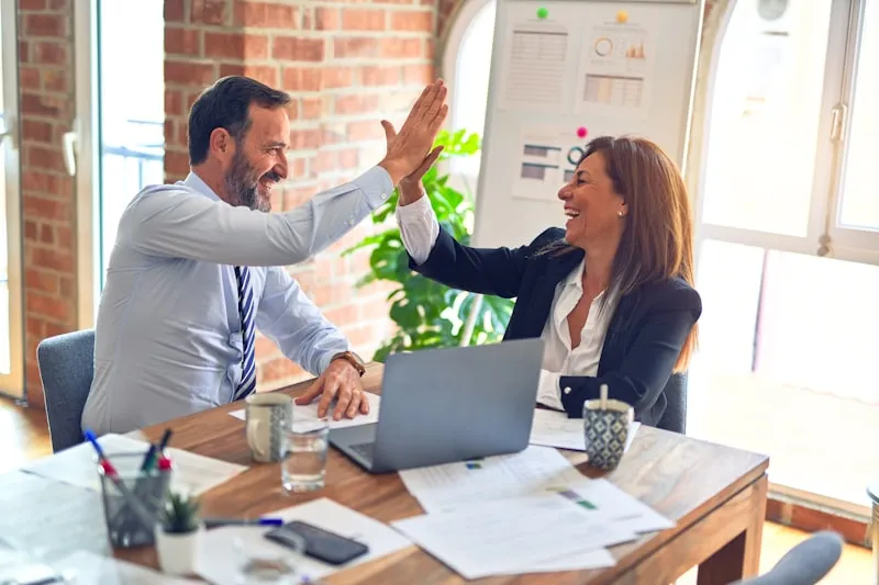 Two business partners celebrating with a high-five